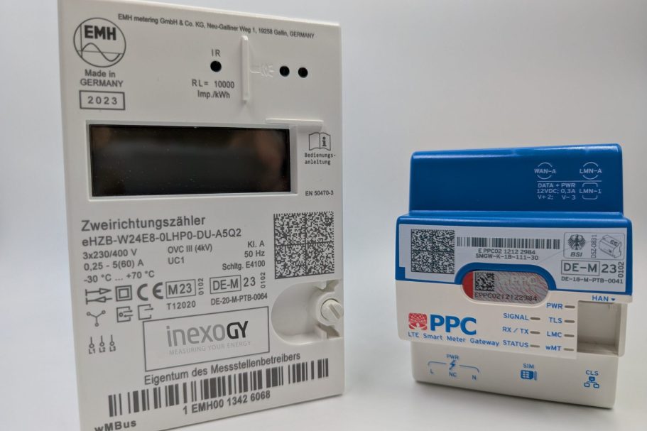 Smart Meter Zwei Stromzähler auf einem Tisch, einer mit grauer Rückseite und der andere blau.