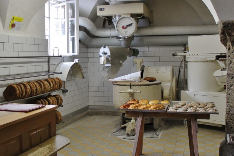 Gewerbekunden Bäckerei mit Backofen, Arbeitsfläche und verschiedenen Broten auf einem Tisch.